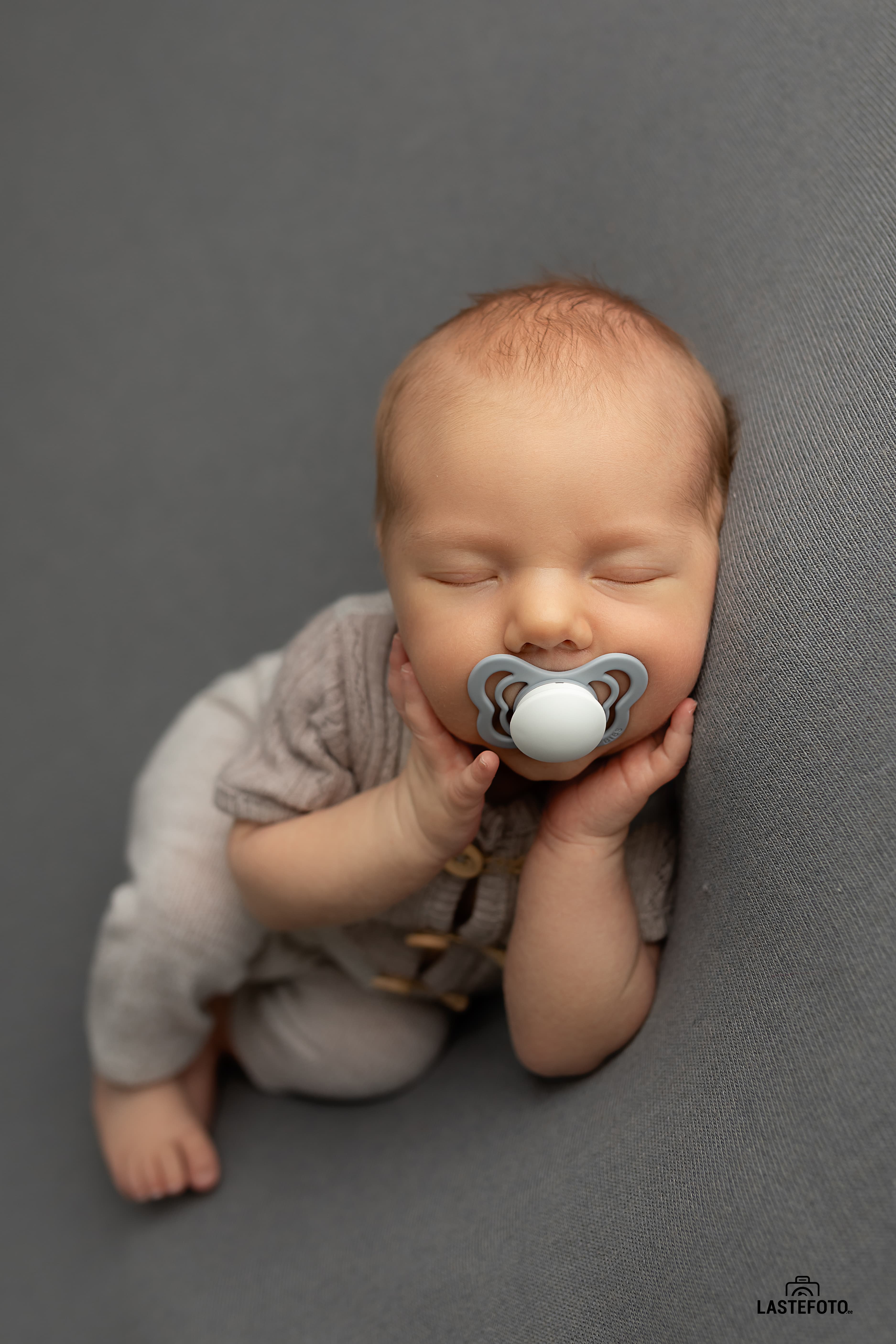 Newborn with pacifier at photo shoot