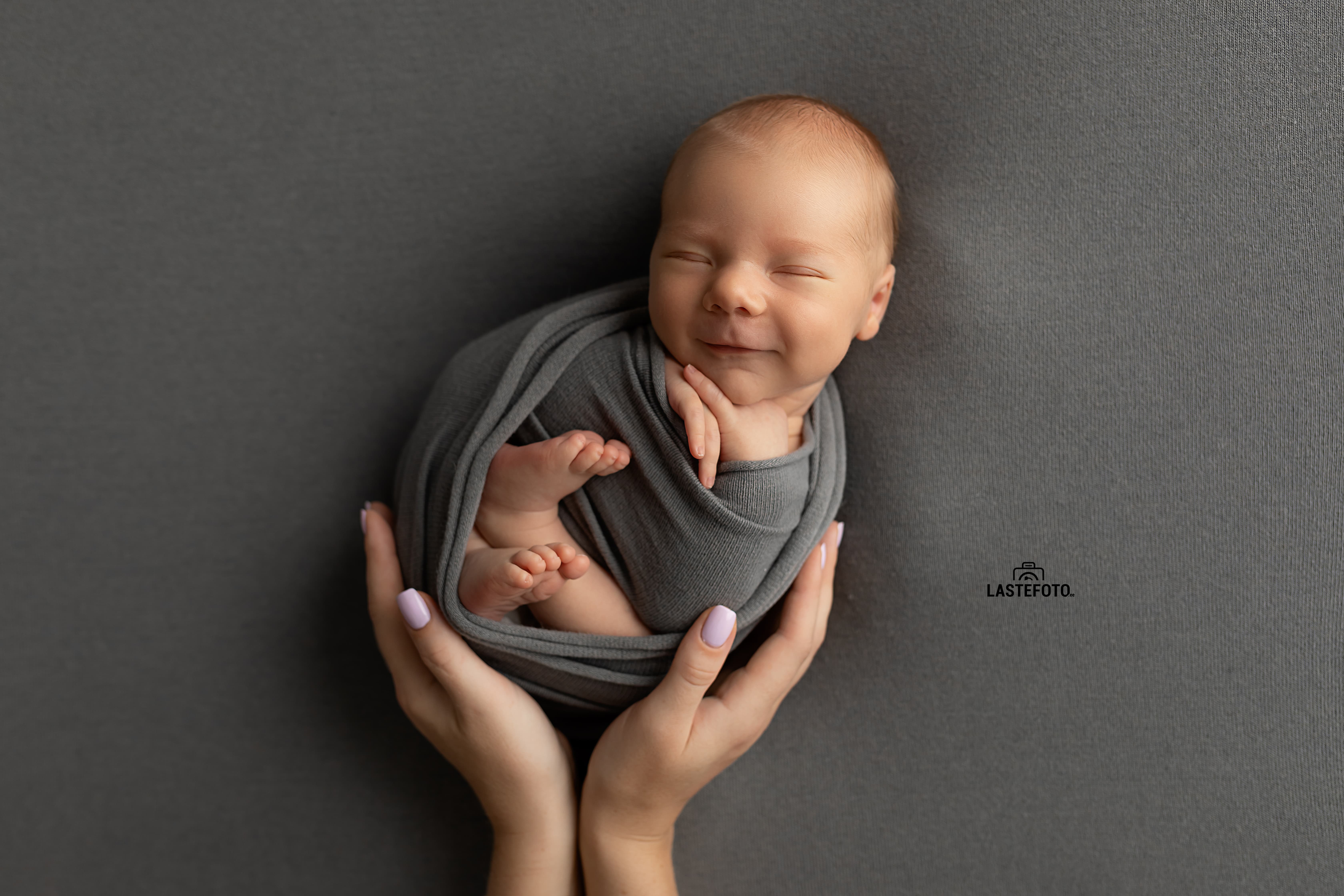 Smiling newborn baby at newborn photo shoot